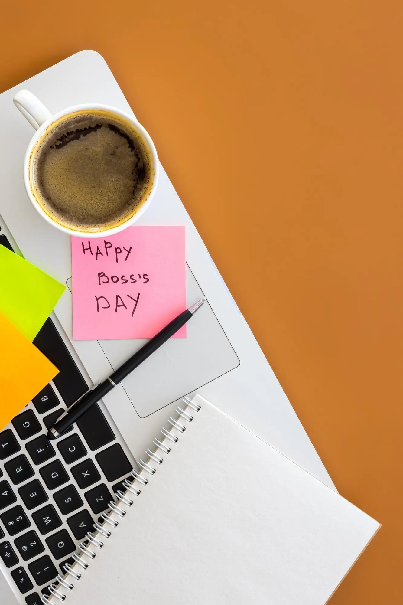 Boss Day concept: flat lay of a laptop and a cup of coffee on a table.