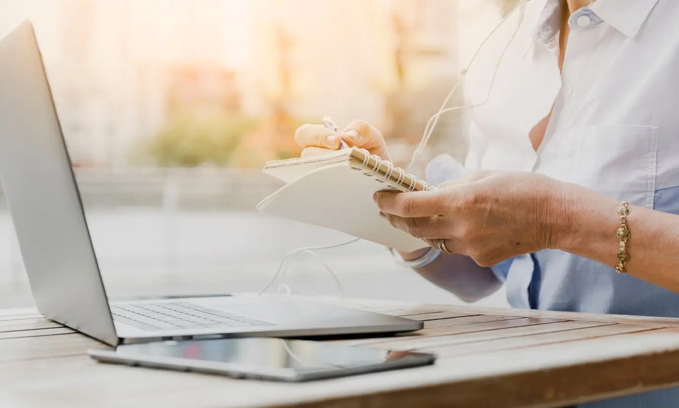 Close-up view of a person writing on the notebook.