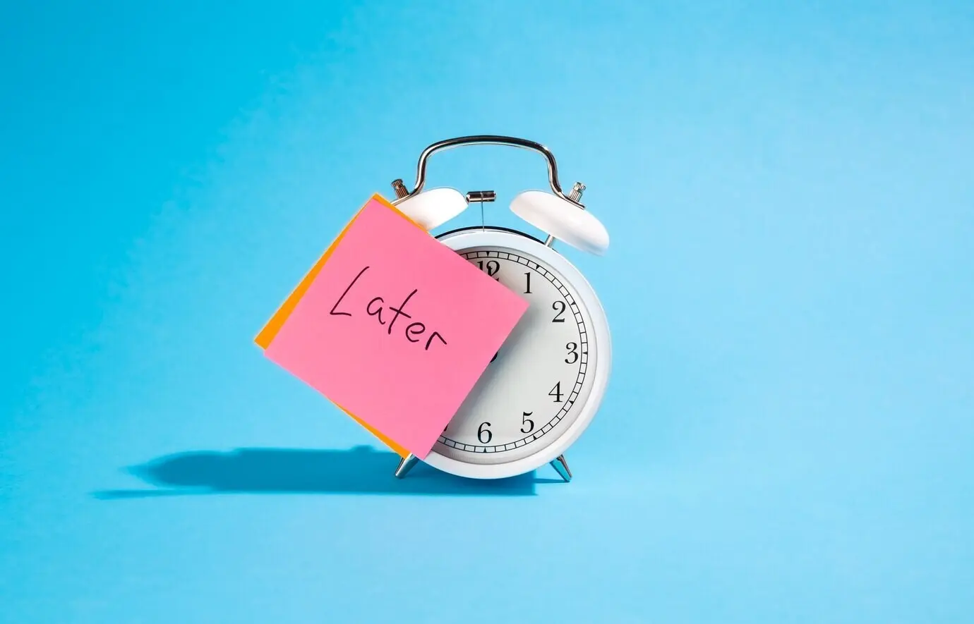 A white alarm clock and a sticker with the word 